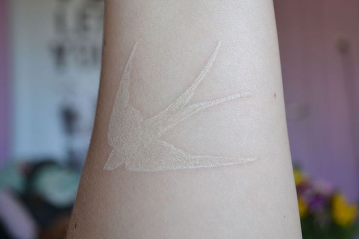 White tattoo on pale skin