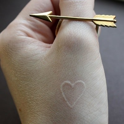 White tattoo on hand