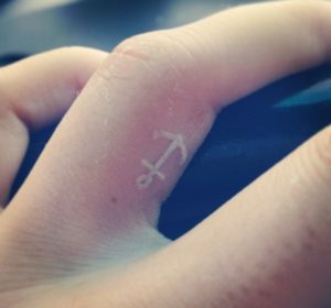 White tattoo design on finger