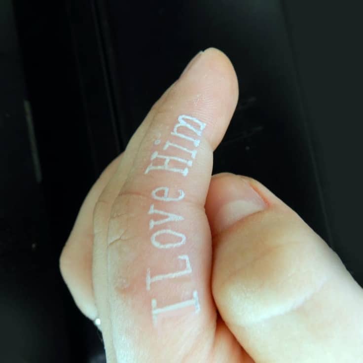 white finger tattoo design on a finger