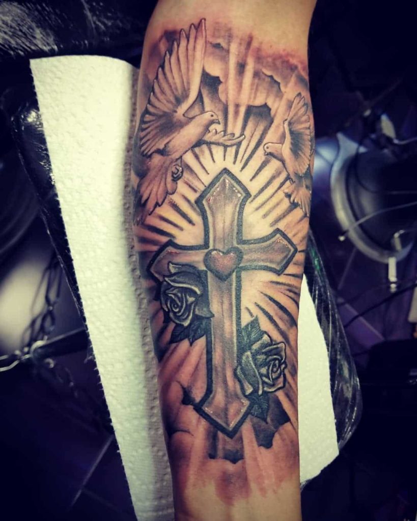 cross tattoo on hand with doves